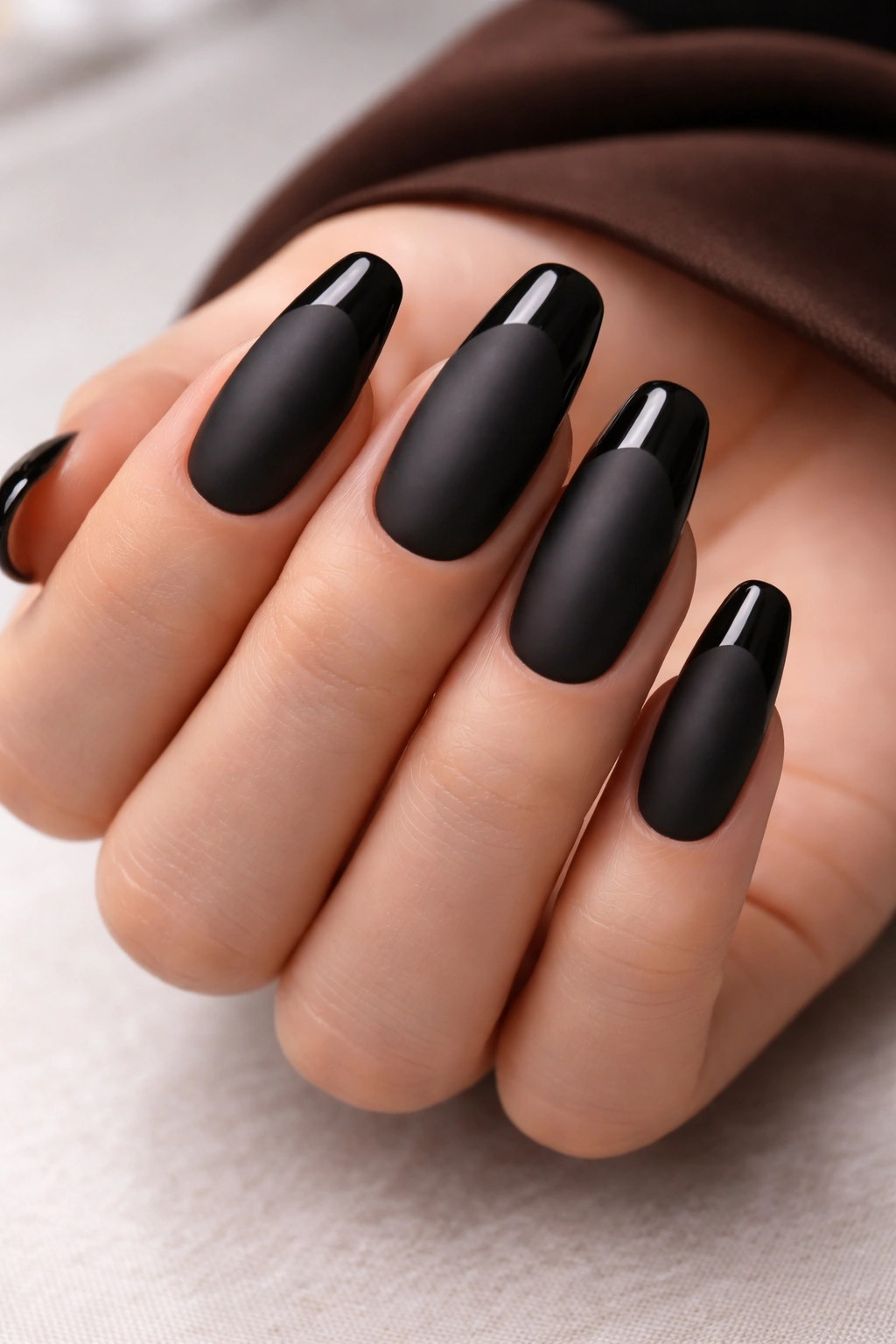 Close-up of matte black nails with glossy tip contrast