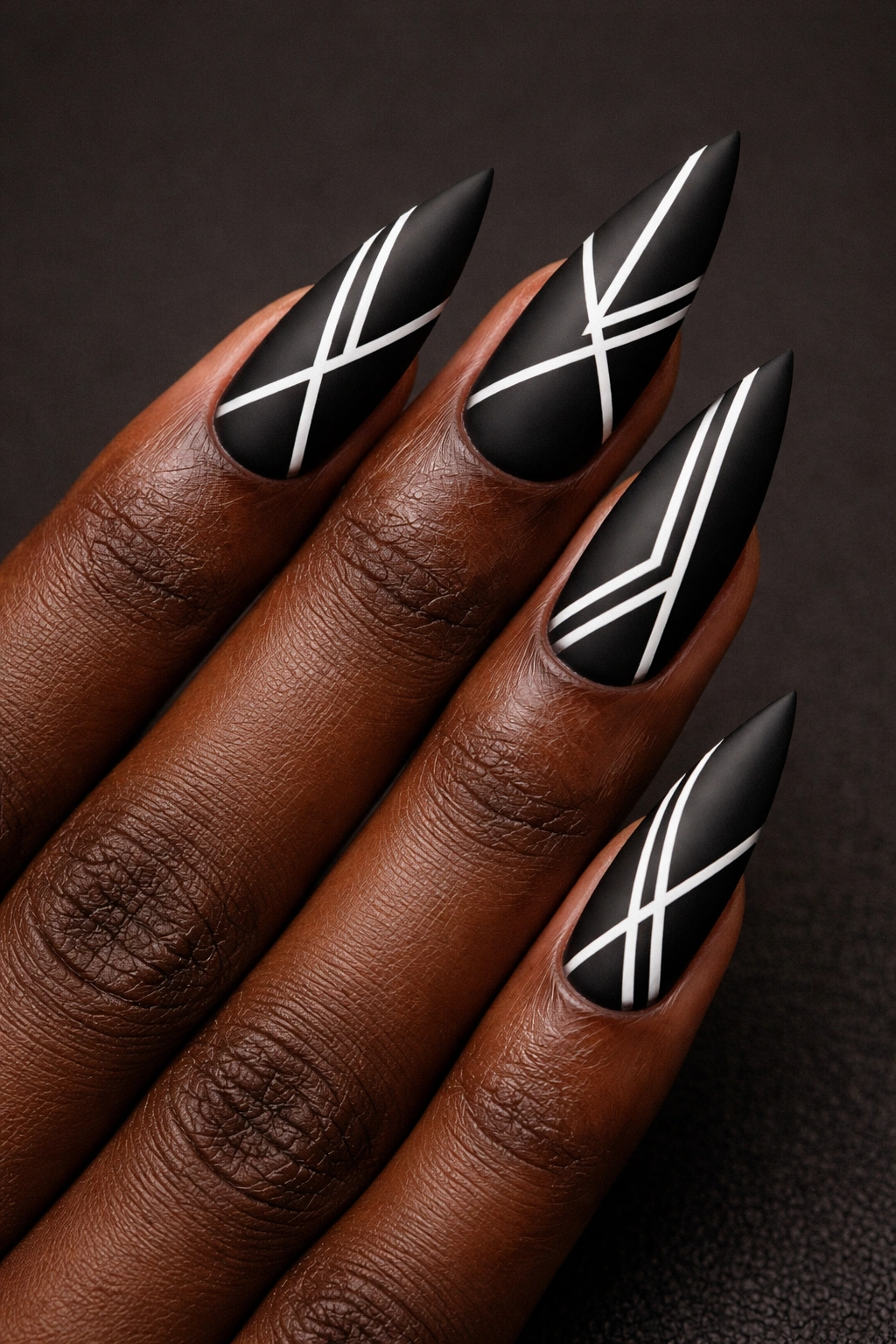 Matte black stiletto nails with white geometric nail art