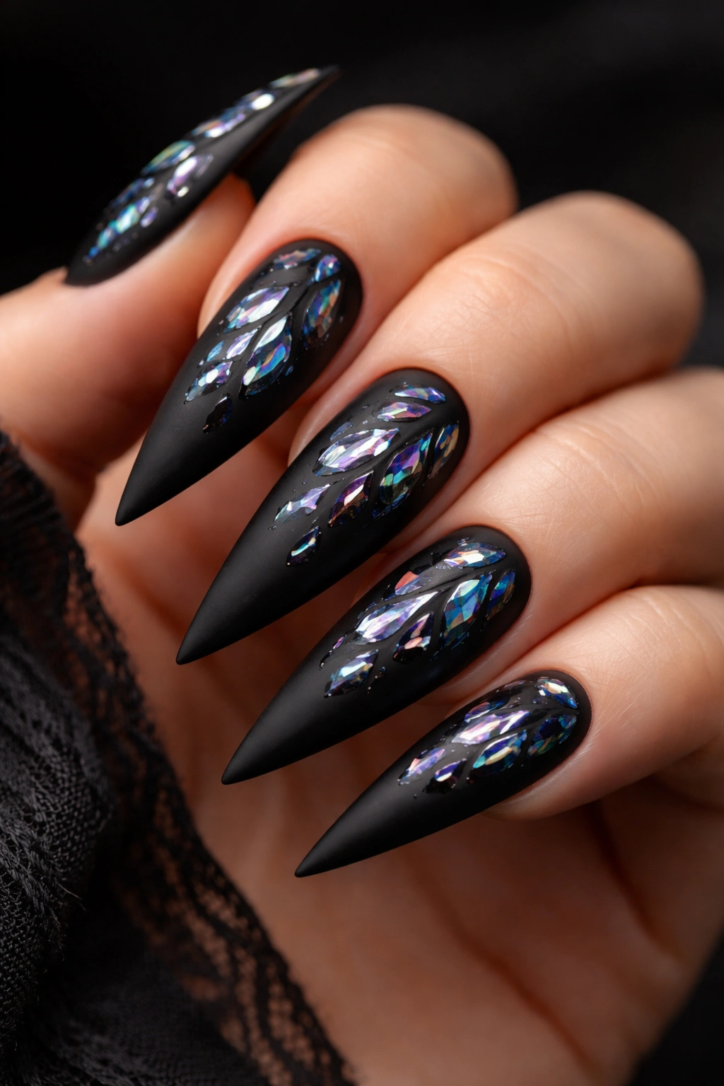 Close-up of matte black stiletto nails with holographic shattered glass