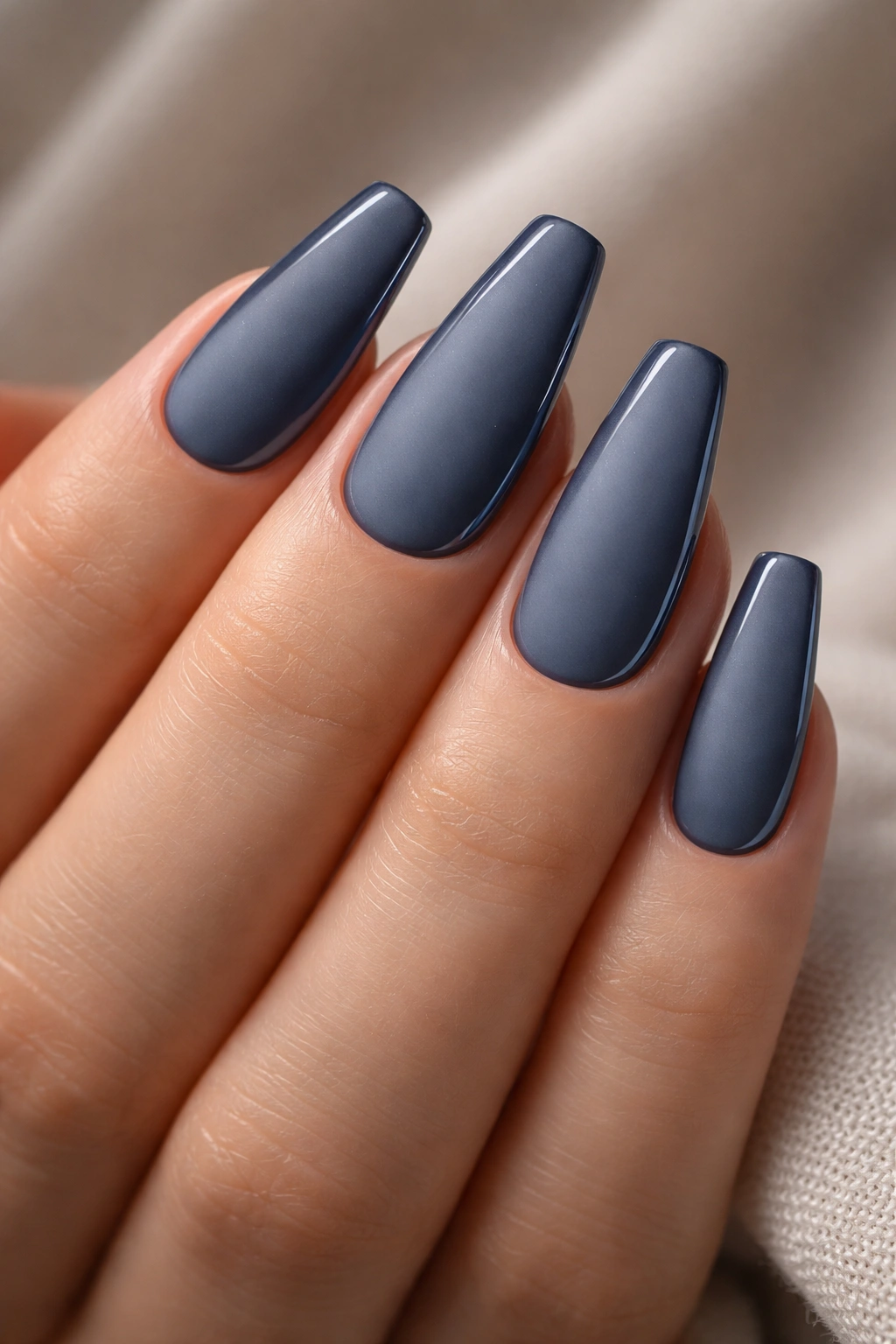 Close-up of matte storm-blue nails with glossy side edges on a hand