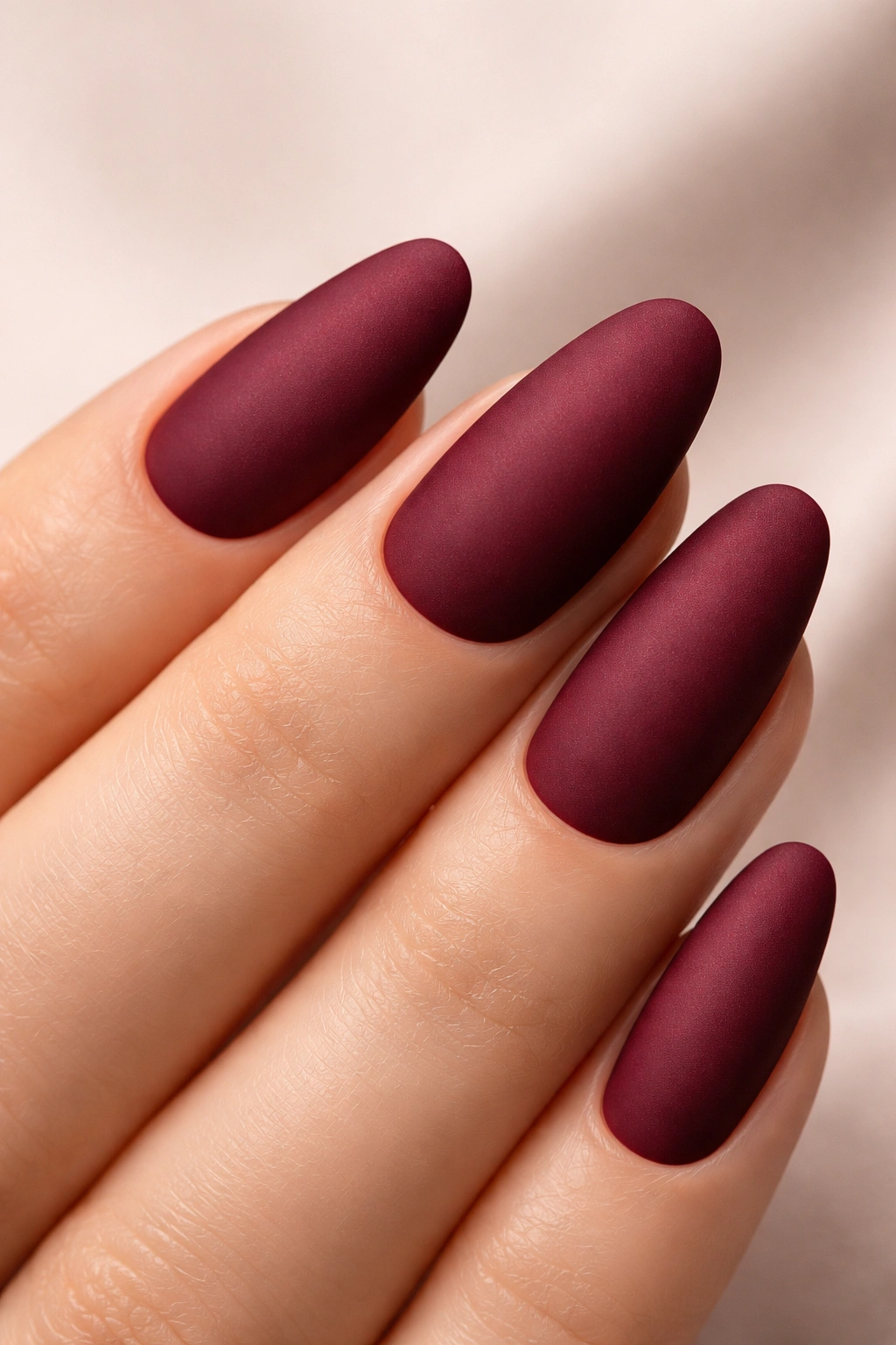 Close-up of burgundy nail with matte velvety finish