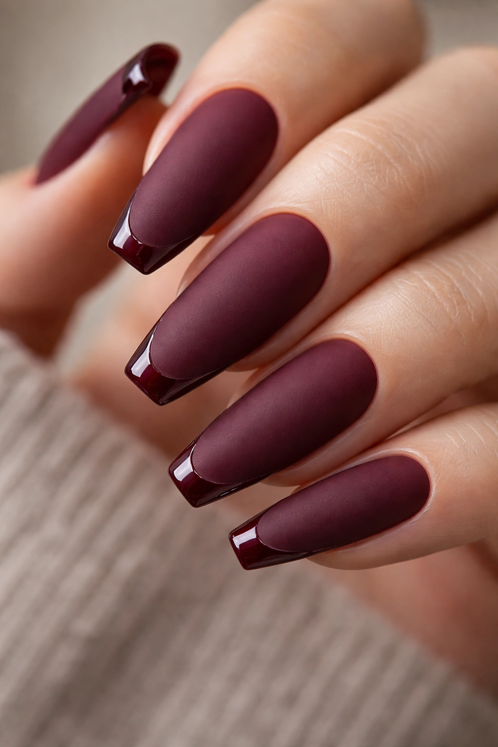 Matte burgundy nails with a thin glossy edge line