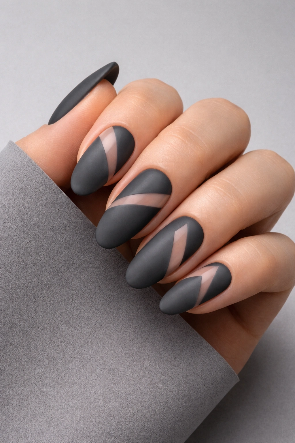 Close-up of matte charcoal nails with negative-space design
