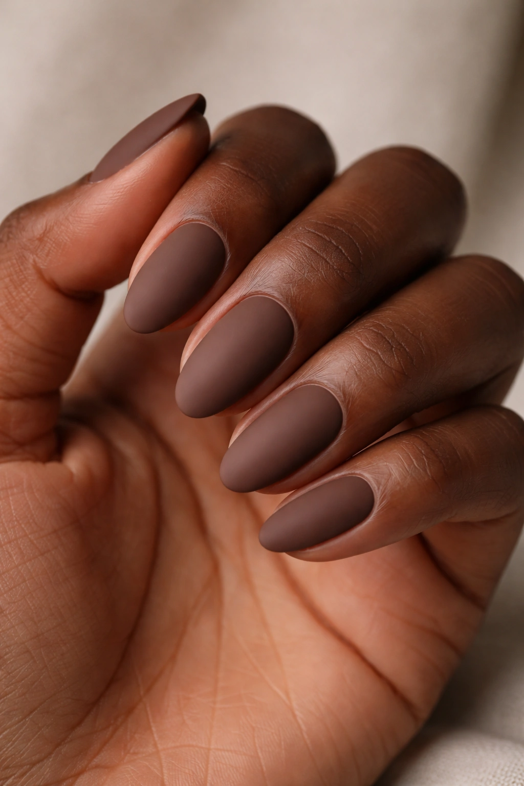 Close-up of matte cocoa almond nails with velvet finish