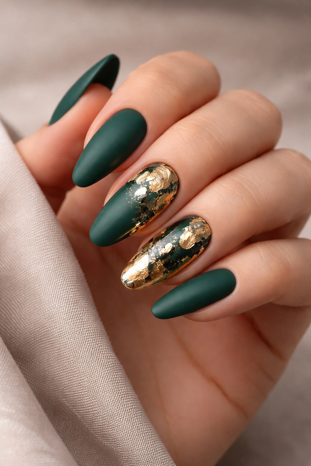 Matte green nails with glossy gold foil accents for contrast.