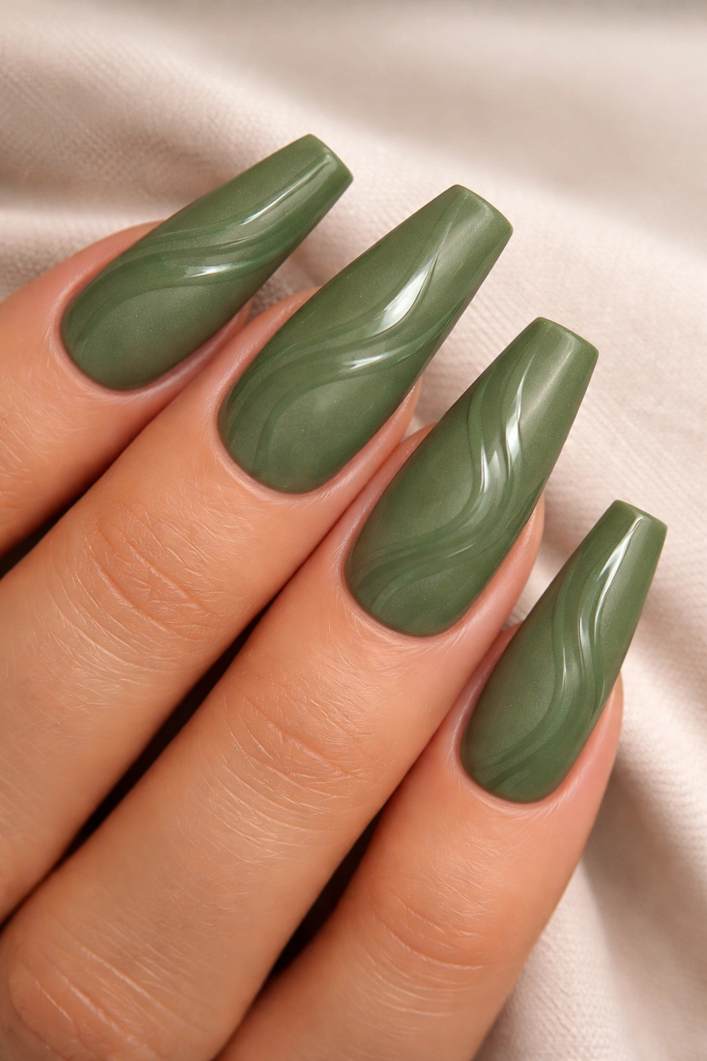 Close-up of matte moss green nails with glossy swirls