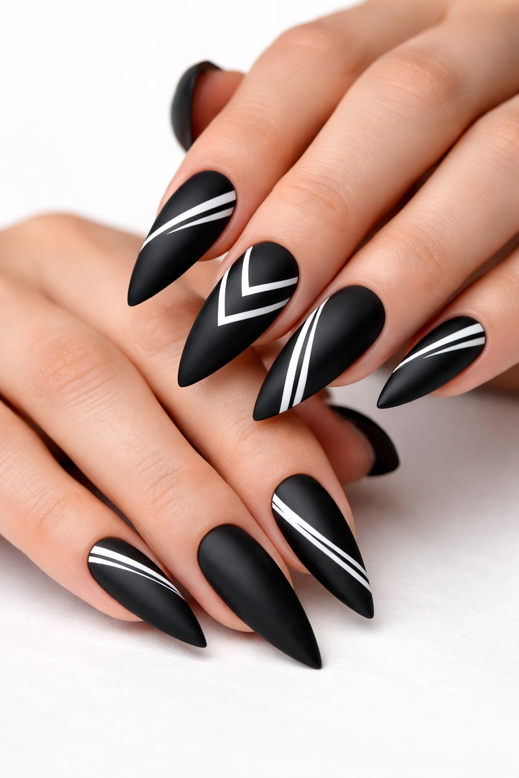 Matte black stiletto nails with white geometric shapes