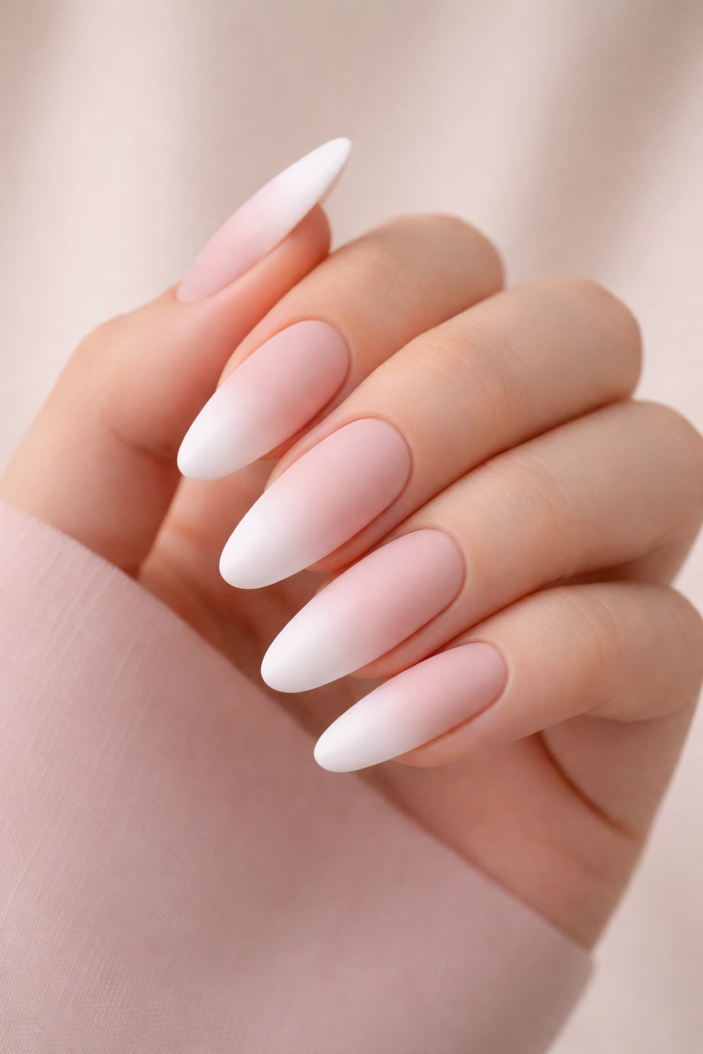 Close-up of long rounded nails with matte pink-to-white ombre tips