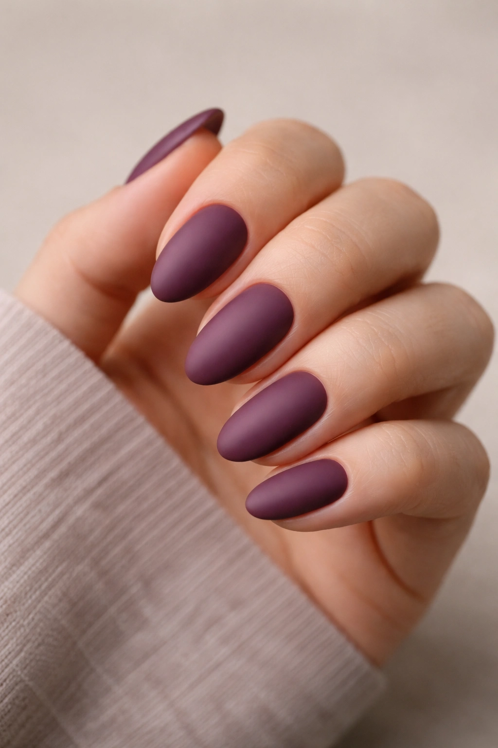 Matte plum short almond nails on hand