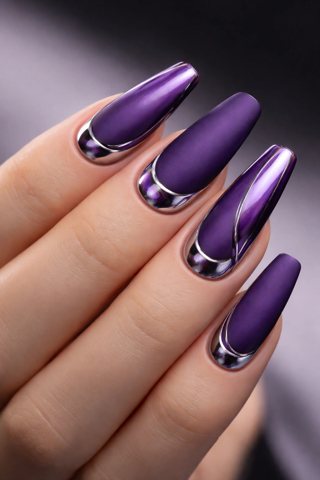 Matte purple nails with chrome accents on a neutral backdrop