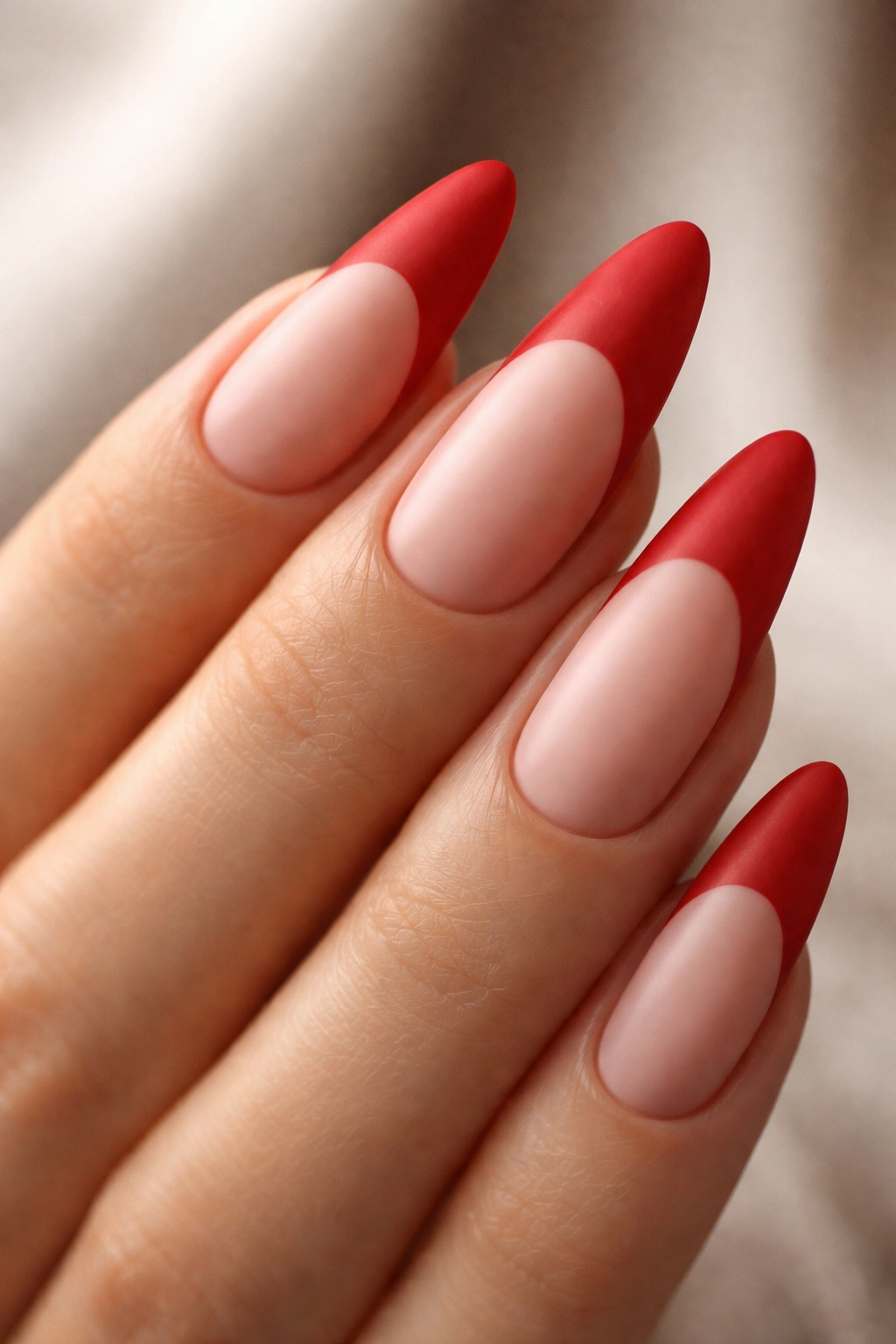 Close-up of sculpted almond nails with matte red tips