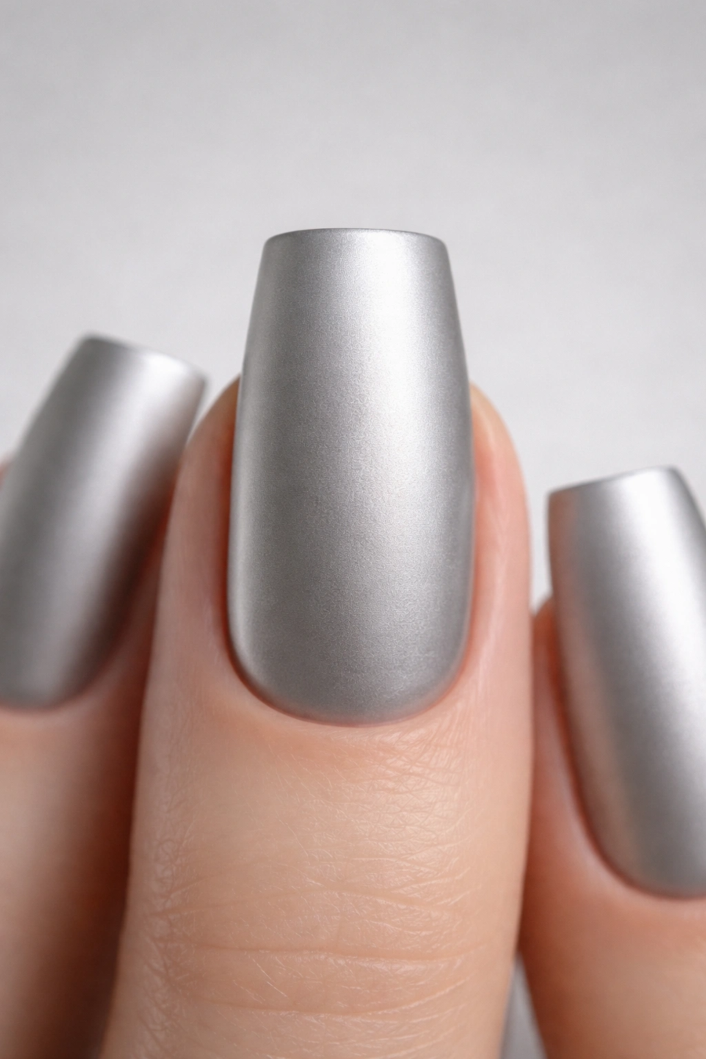 Close-up of a duck nail with matte metallic silver finish