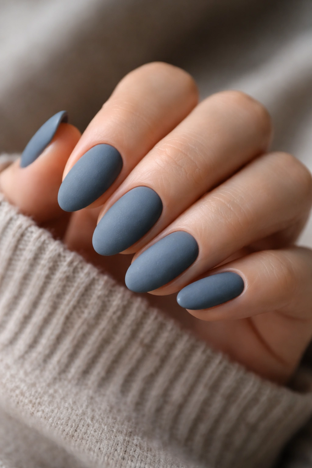 Close-up of matte slate almond nails on a hand