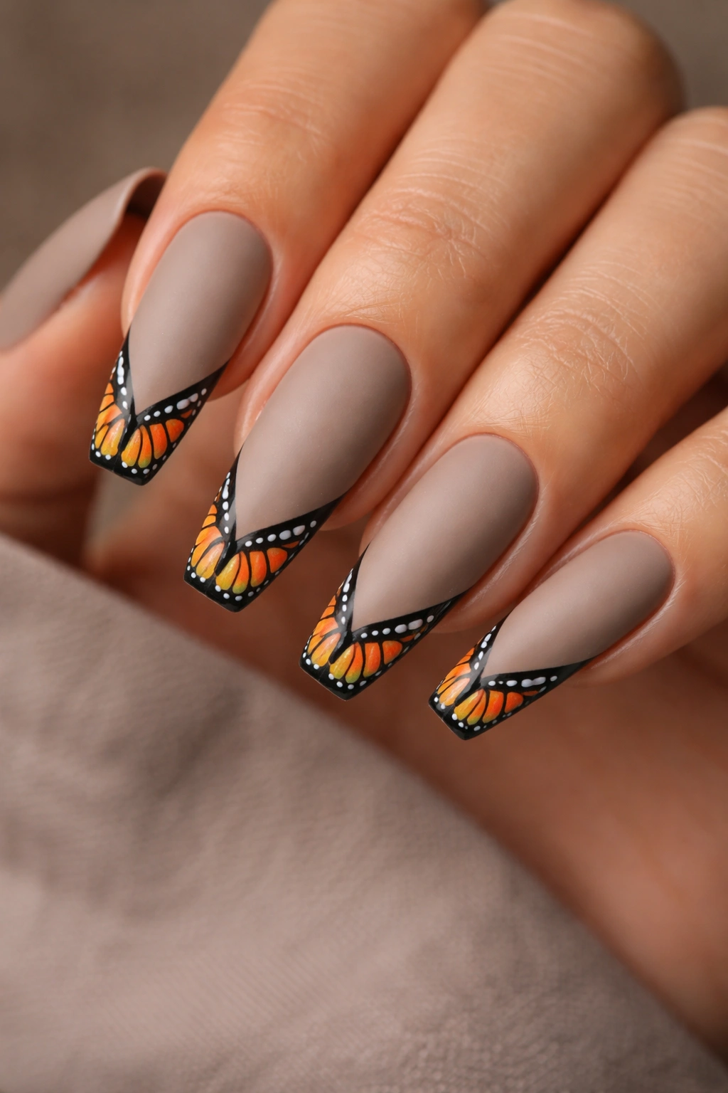 Matte taupe nails with monarch wing tips on the tips