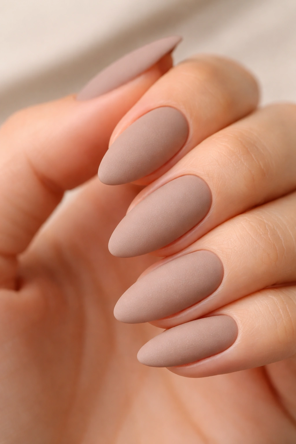 Matte taupe almond-shaped nails with velvety finish