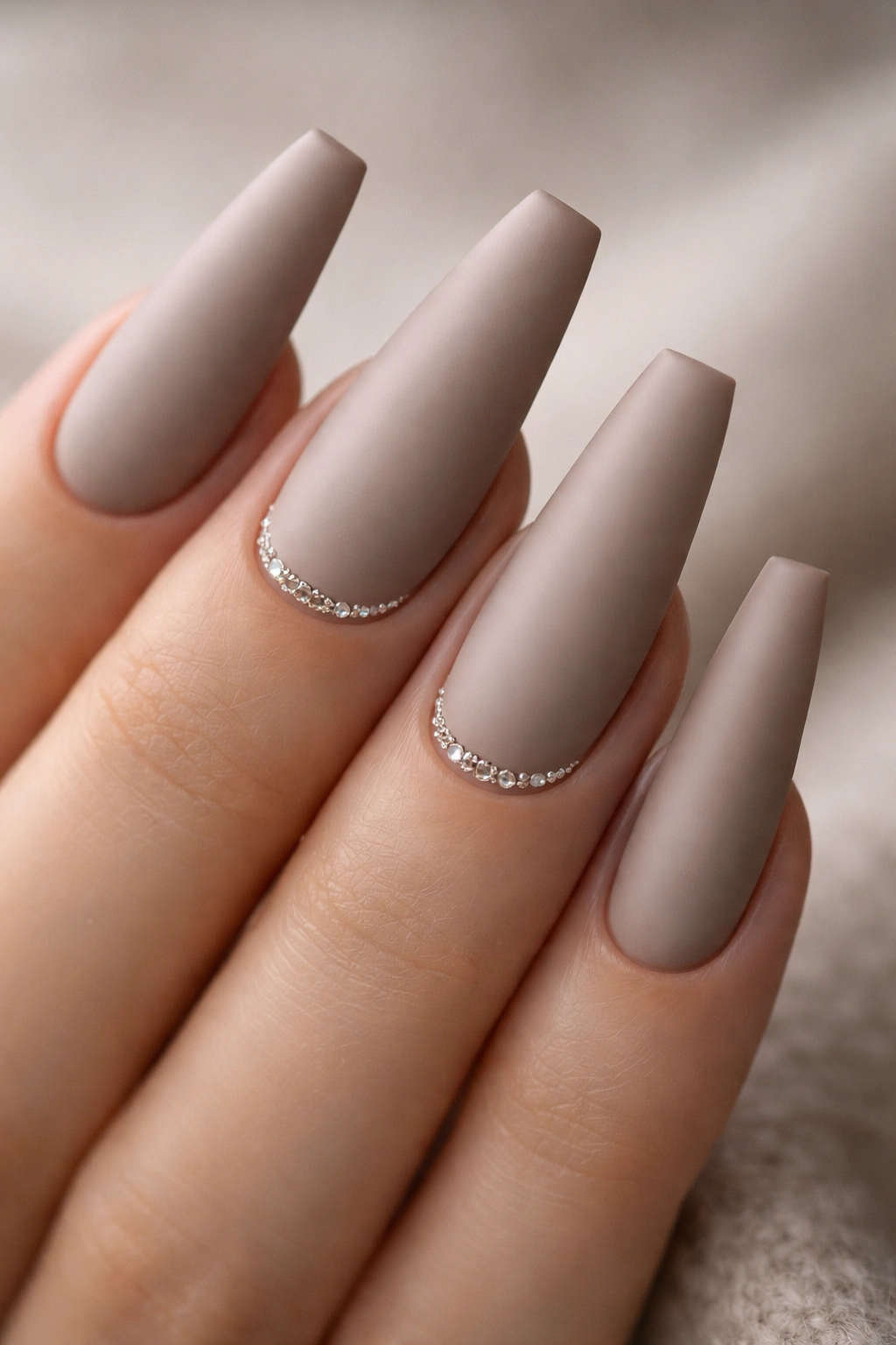 Matte taupe nails with tiny crystals at cuticles on long ballerina nails