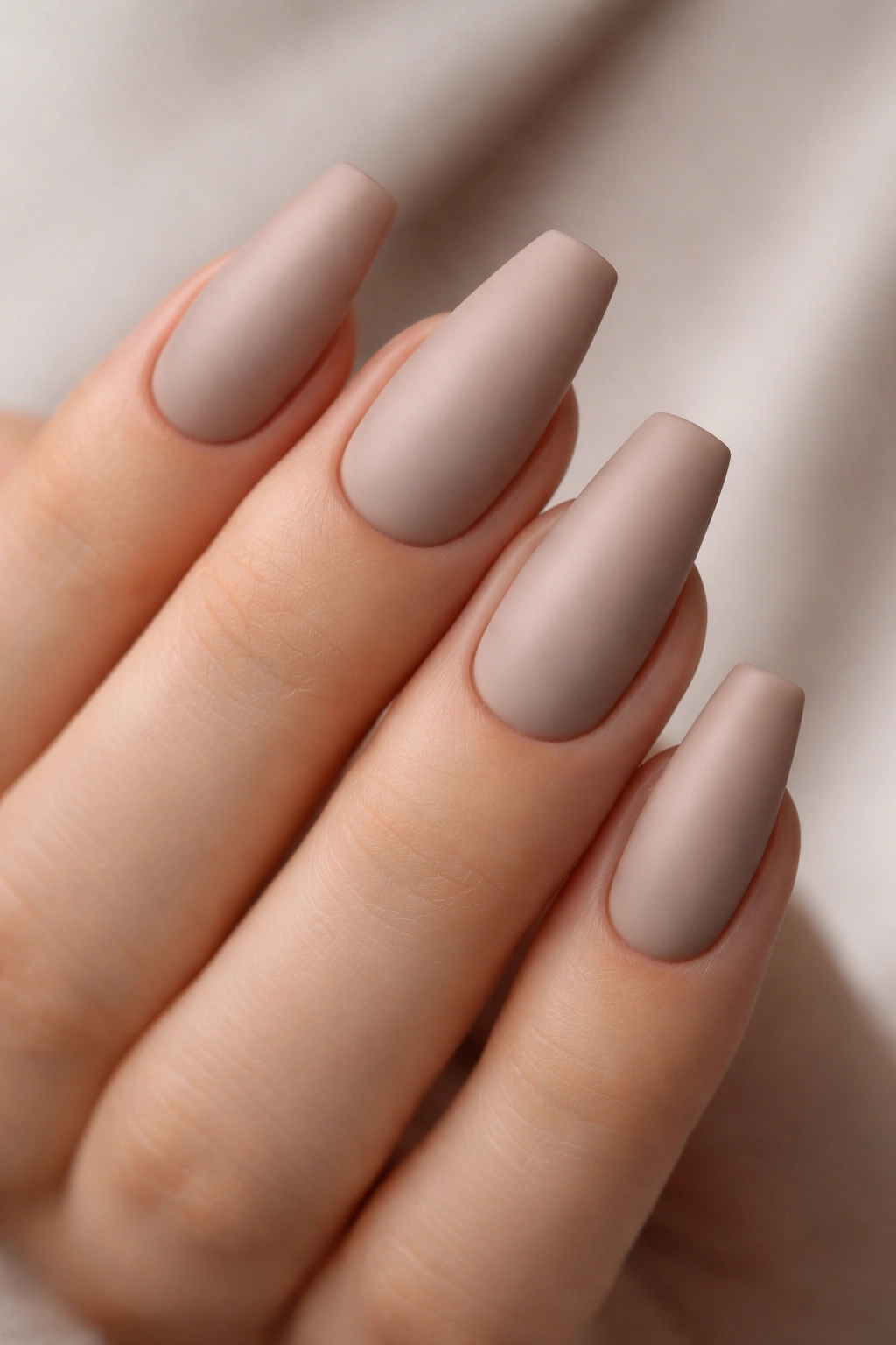 Matte taupe ballerina nails with soft stone tones and velvet texture