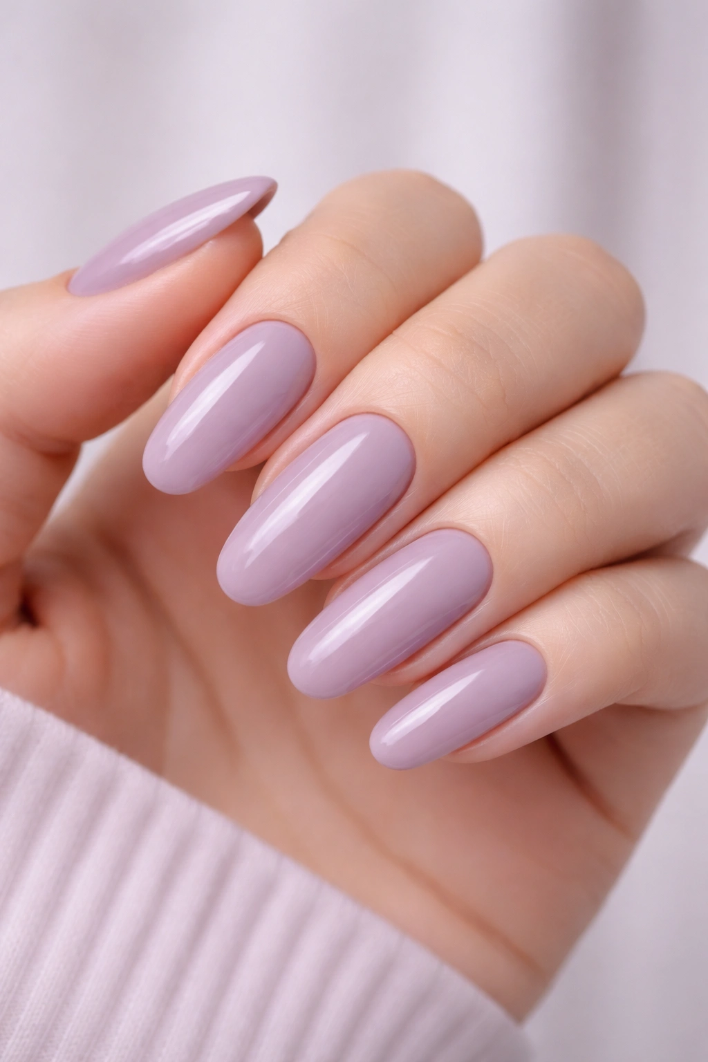 Close-up of long round acrylic nails in light mauve with glossy finish