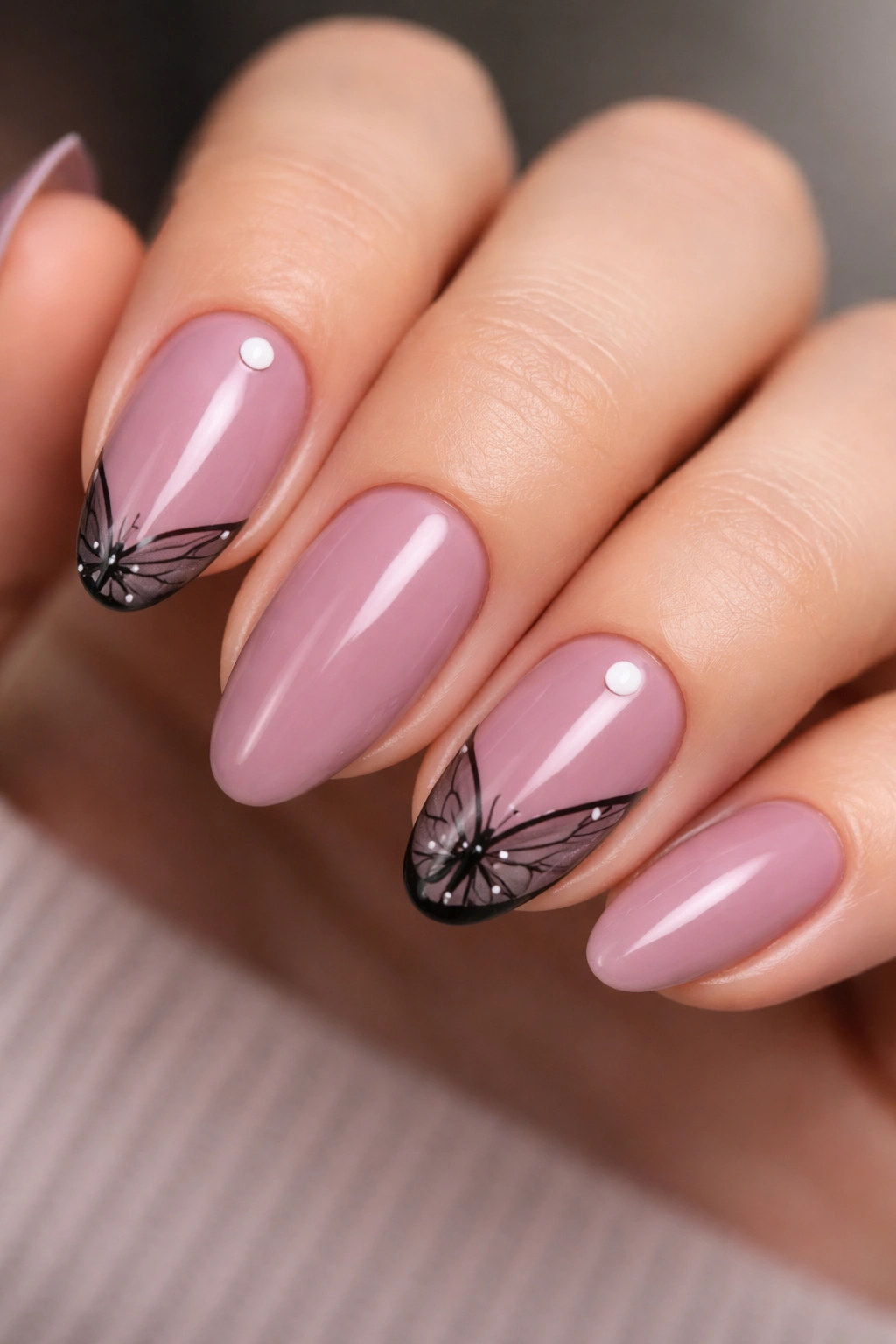 Mauve nails with black wing corners on index and ring fingers