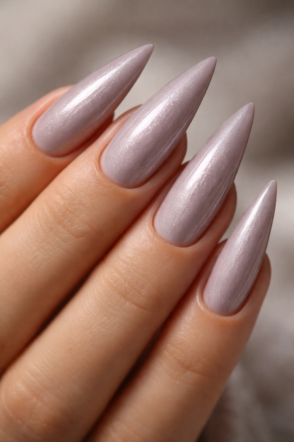 Close-up of mauve stiletto nails with pearl shimmer