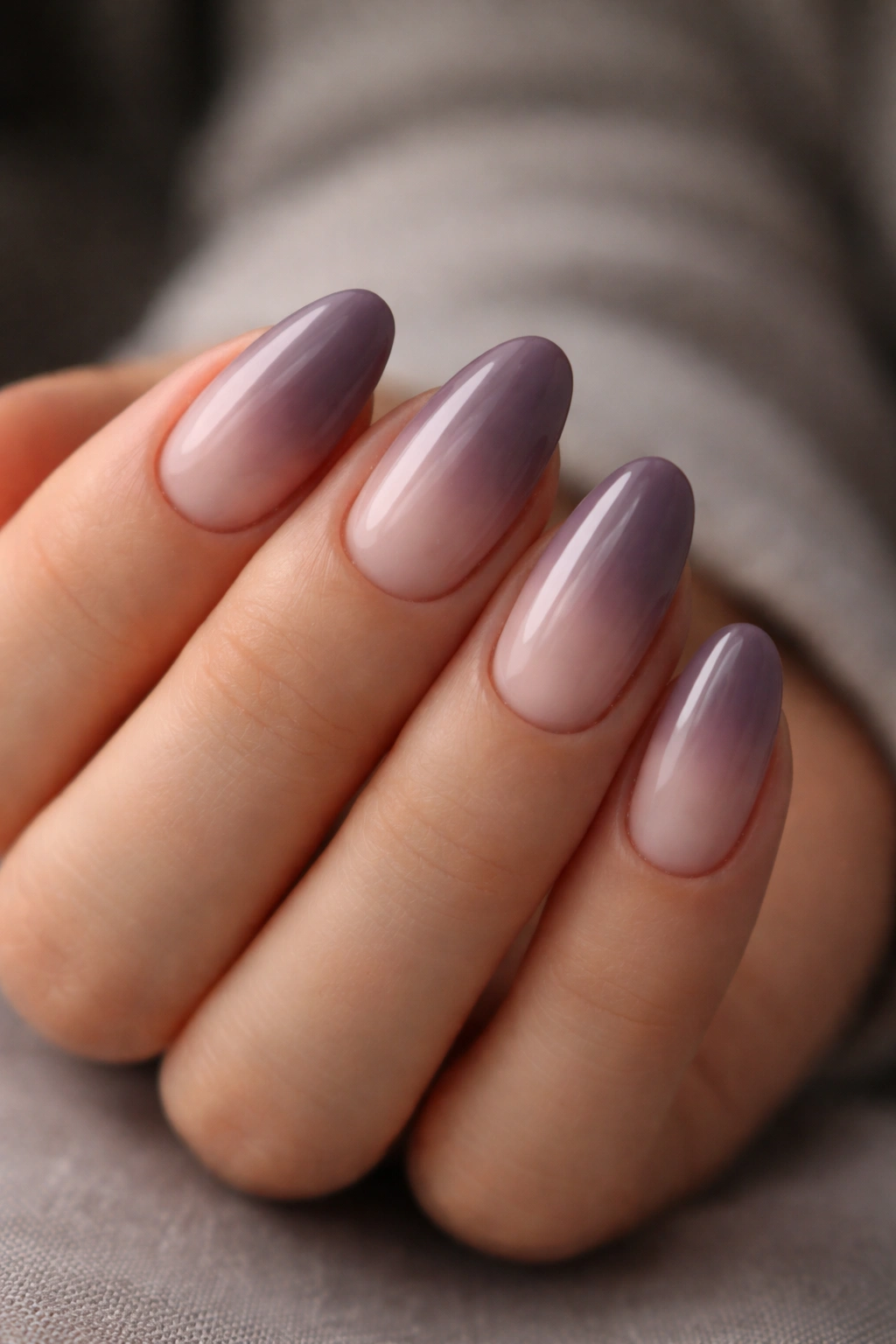 Close-up of short almond nails in mauve ombre with moody edge