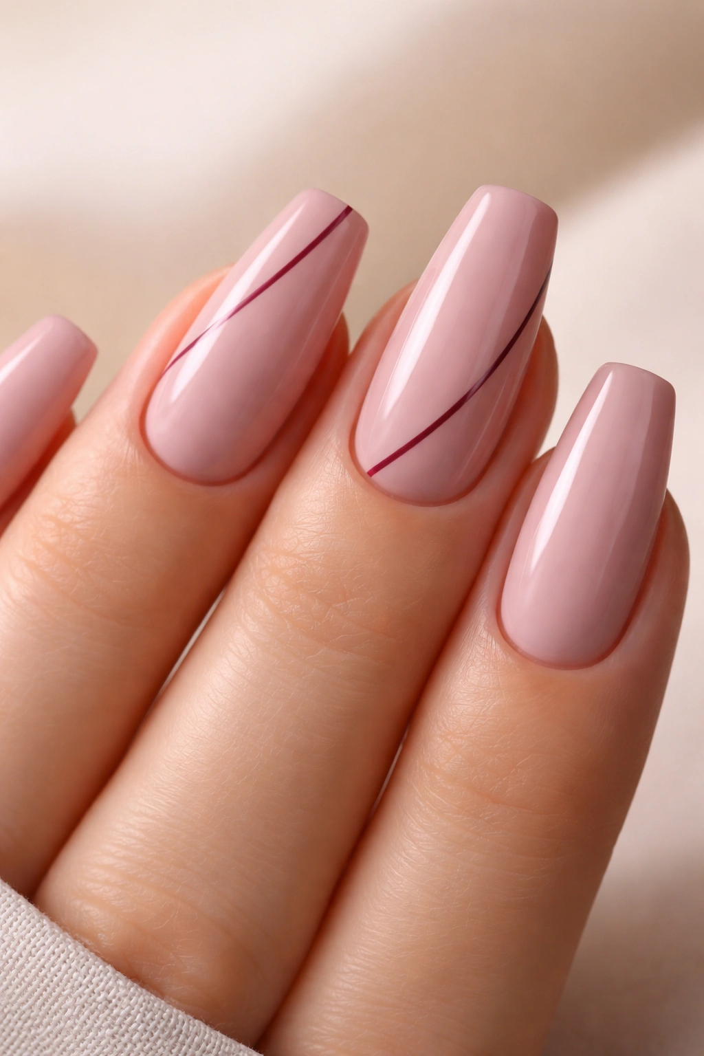 Mauve pink ballerina nails with a thin side-swept white line on two nails