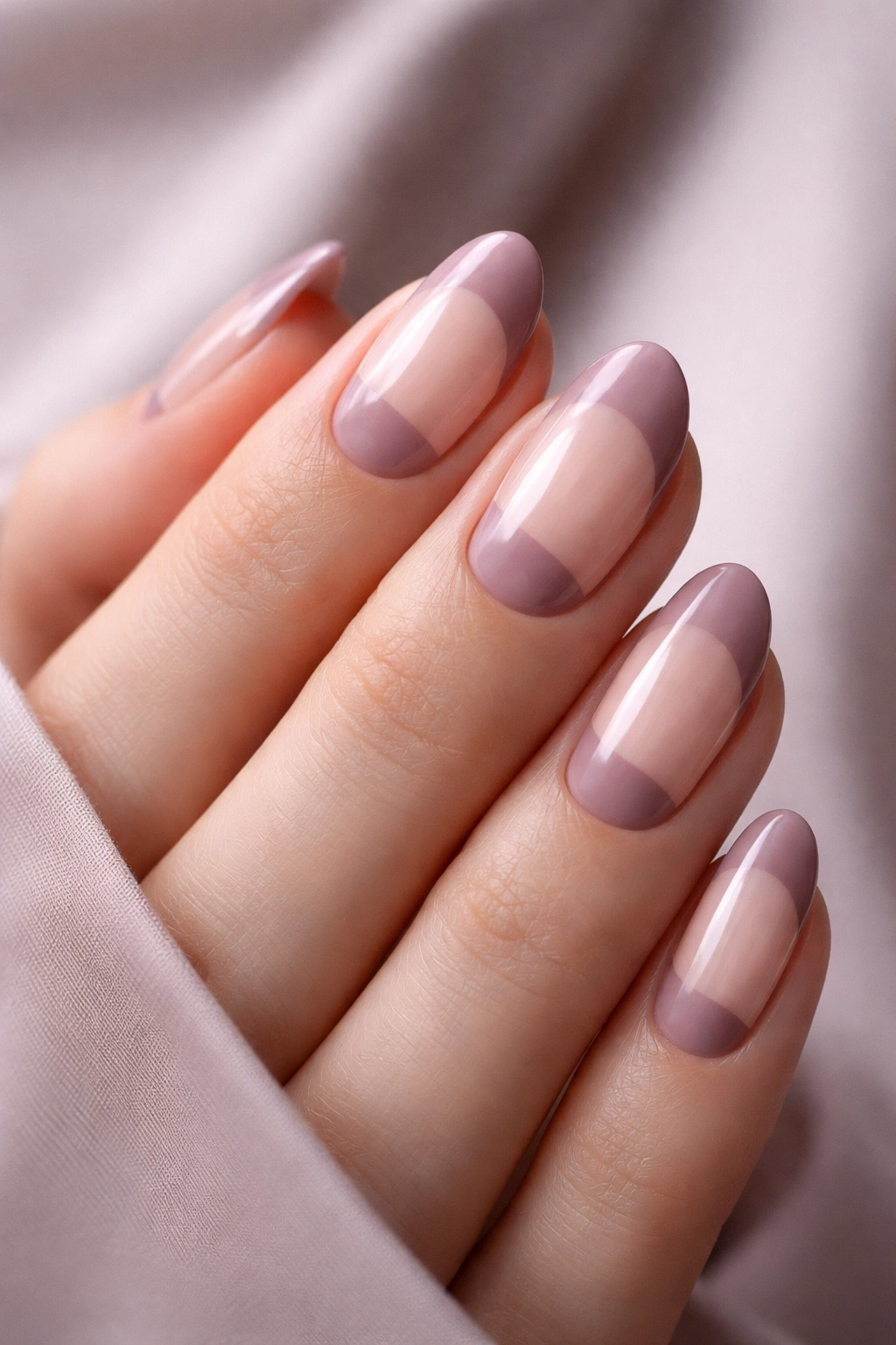 Close-up of mauve reverse French nails with base lunula accent on natural nails