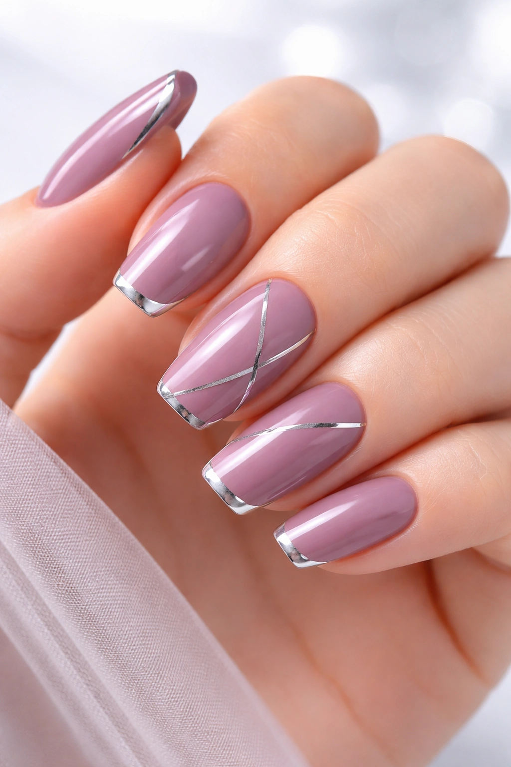 Close-up of mauve nails with silver accents on a clean hand; cool, modern look