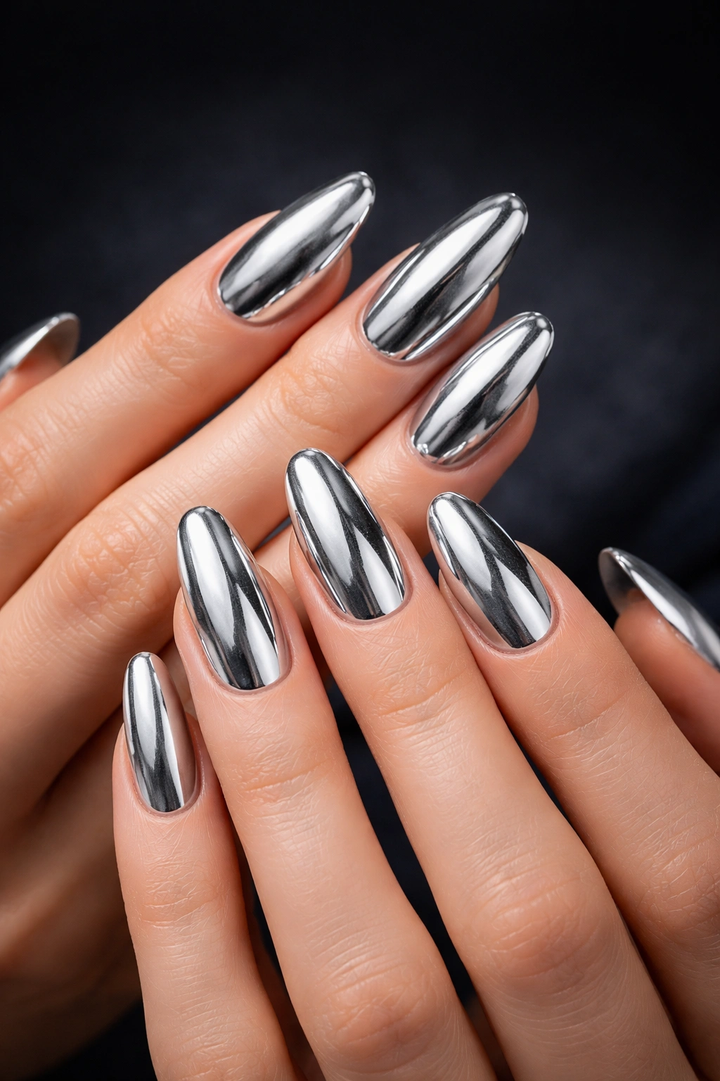 Metallic silver nails catching light against a dark backdrop