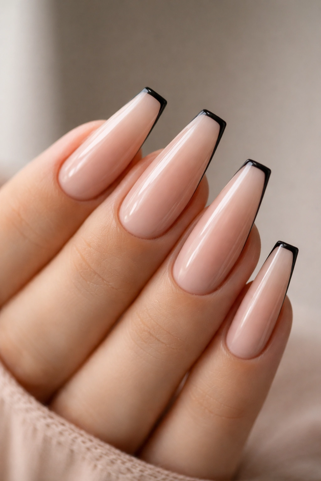 Long nude ballerina nails with a micro-thin black edge.