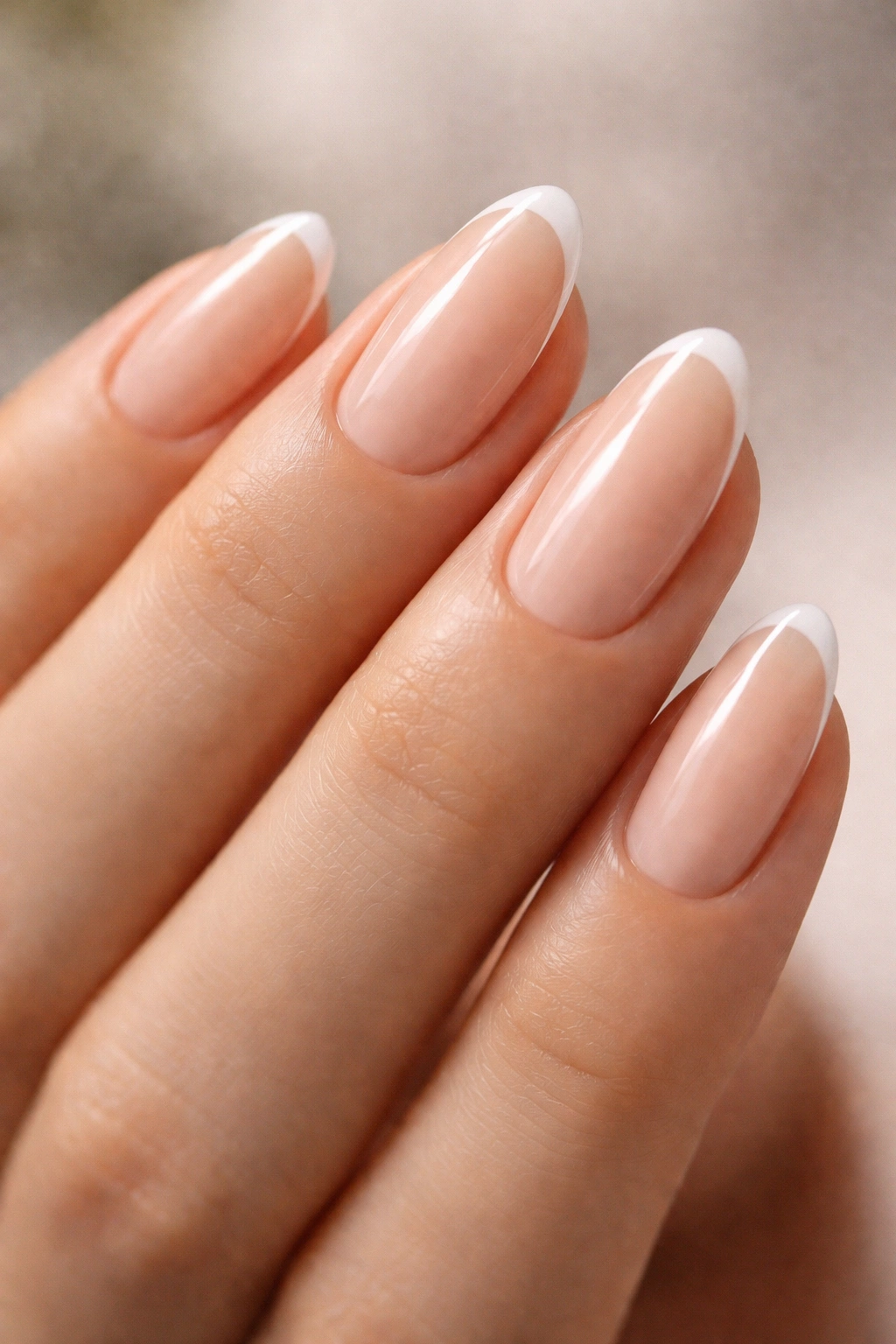 Close-up of tapered oval nails with bare base and ultra-thin white tip