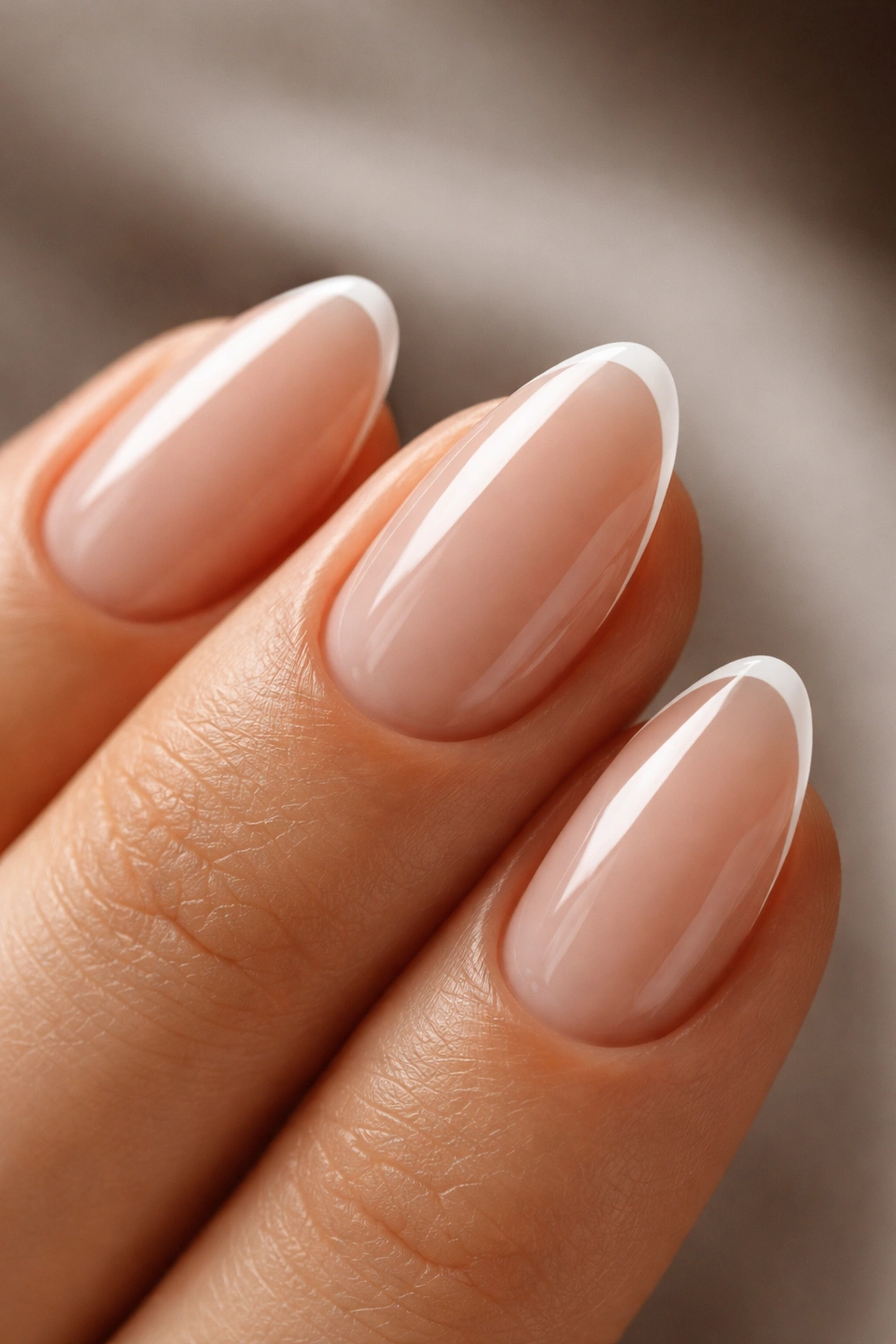 Close-up of an almond-shaped fingernail with a razor-thin white micro French tip