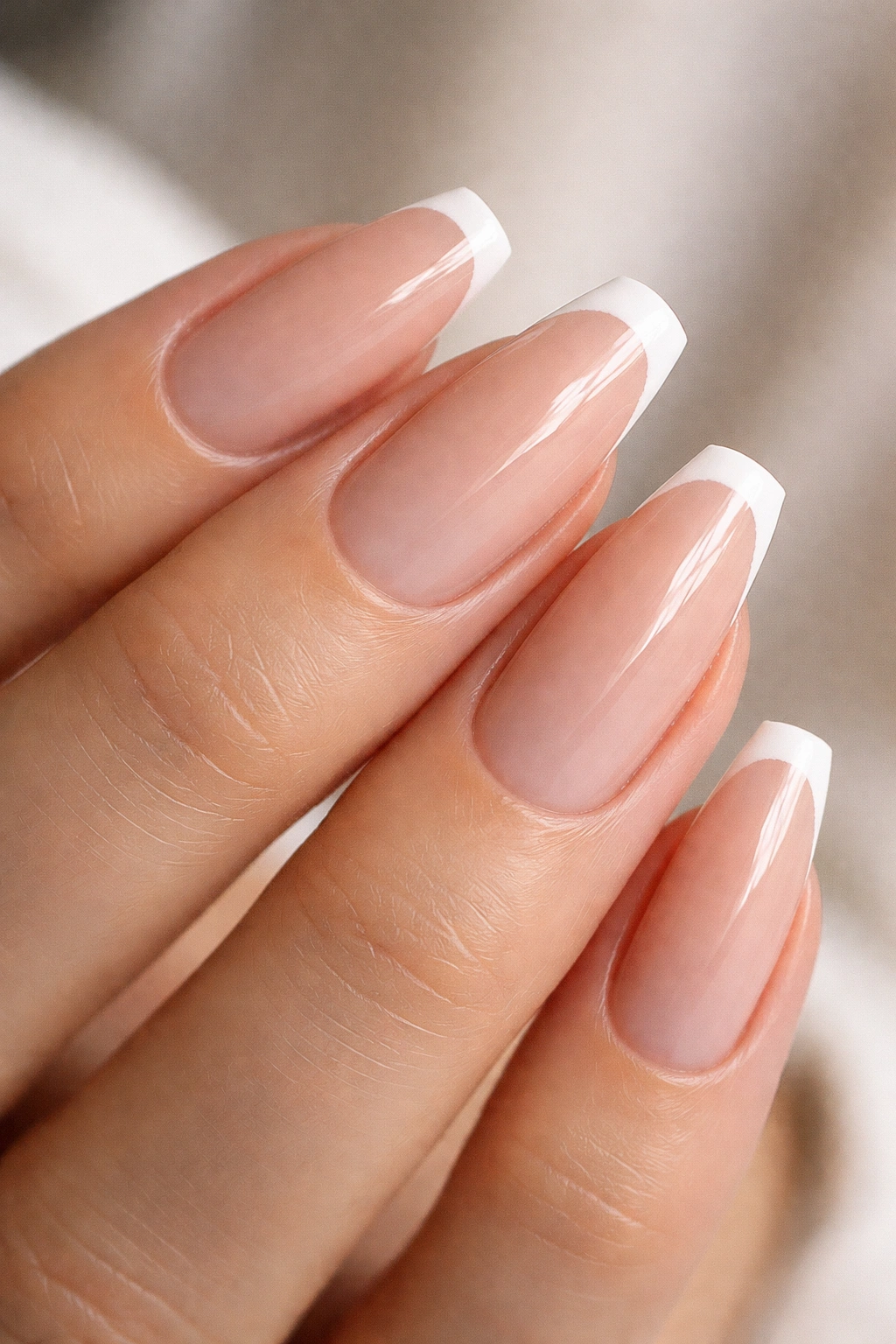 Close-up of micro French ballerina nails with 1mm white tips on nude base
