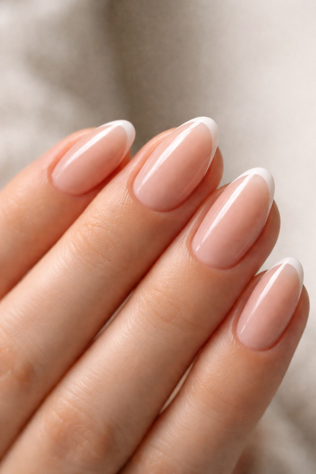 Close-up of ultra-short almond nail with a thin white micro French tip.