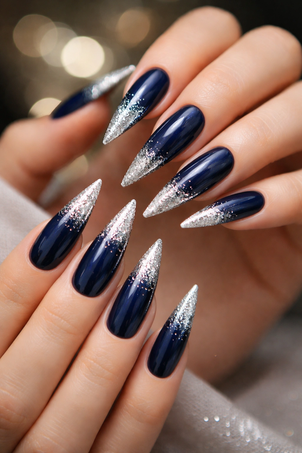 Midnight blue nails with silver glitter tips on stiletto nails