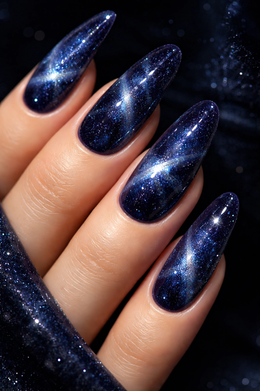 Close-up of midnight blue velvet nails with star-like shimmer