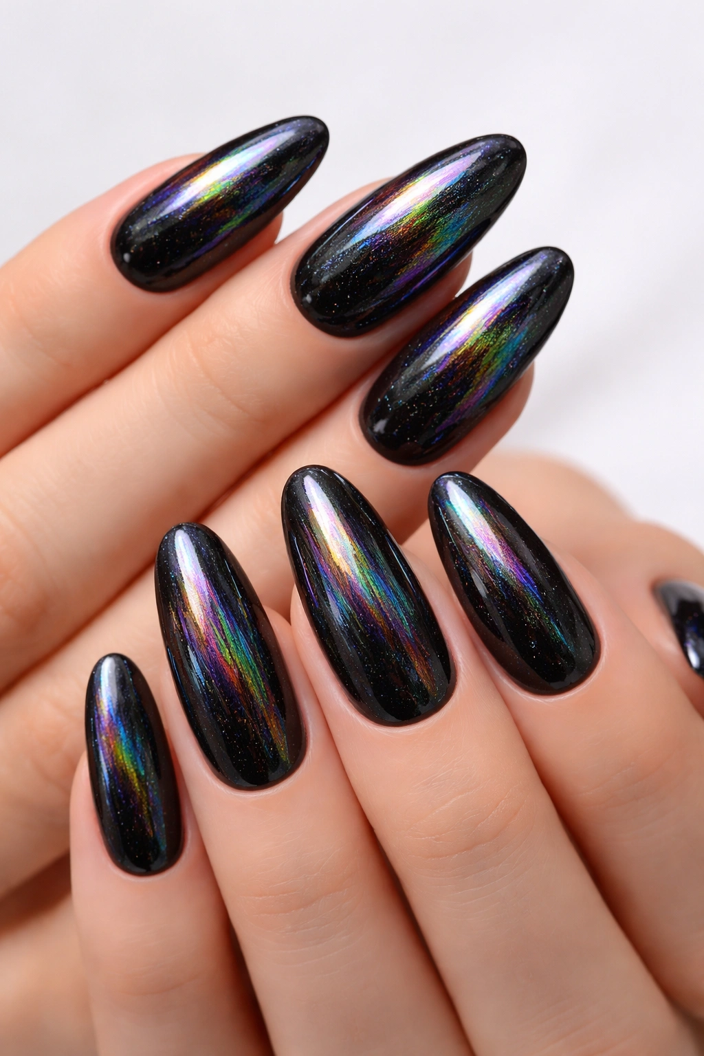 Close-up of long oval nails in midnight black with holographic rainbow shimmer