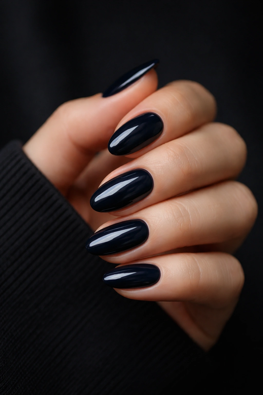 Close-up of midnight navy short almond nails with glossy finish