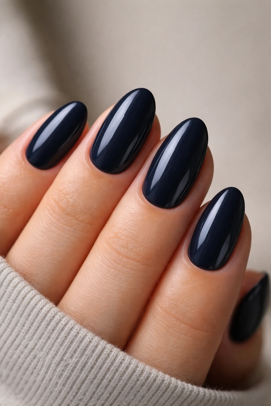 Close-up of midnight navy almond nails with blue sheen