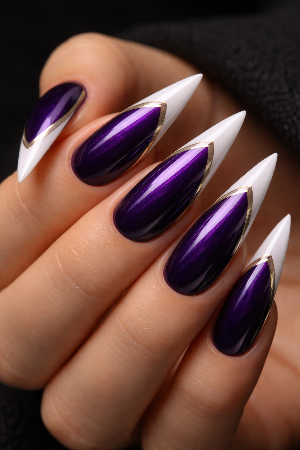 Close-up of midnight purple nails with white tips and metallic stripes along the edges