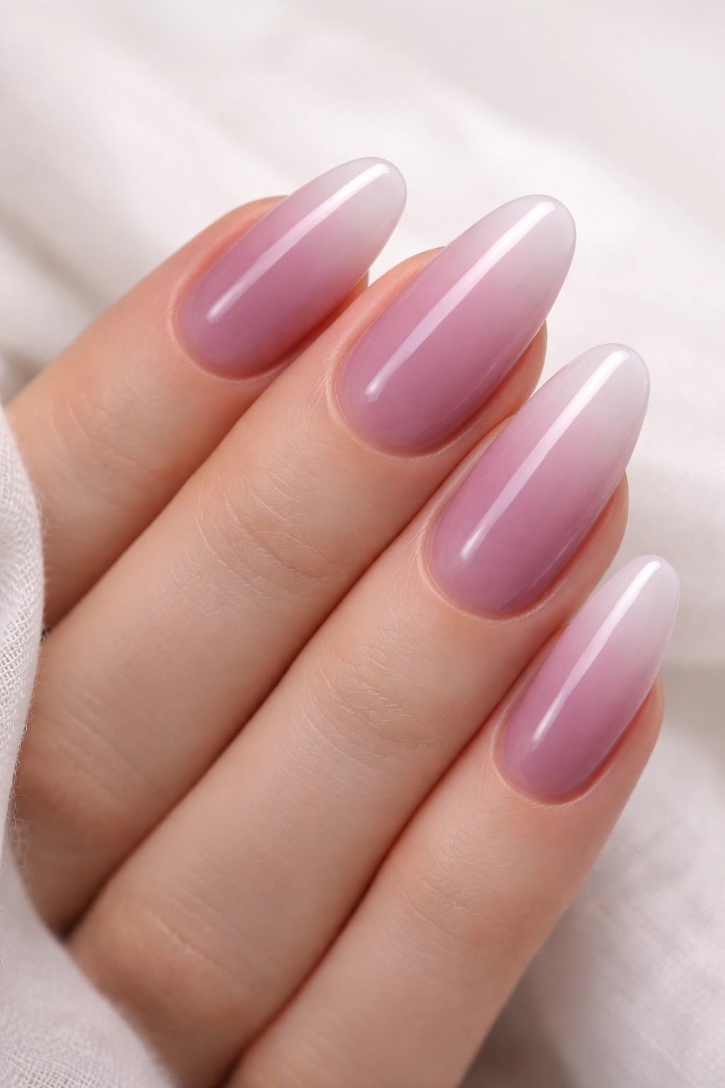 Close-up of milky mauve gradient nails on long ovals