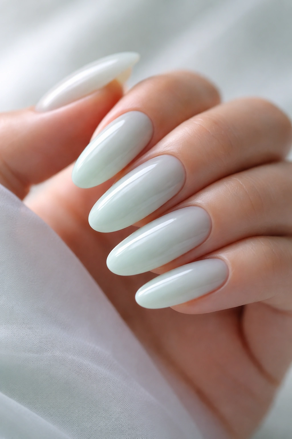 Close-up of creamy mint green milk bath nails on long ovals