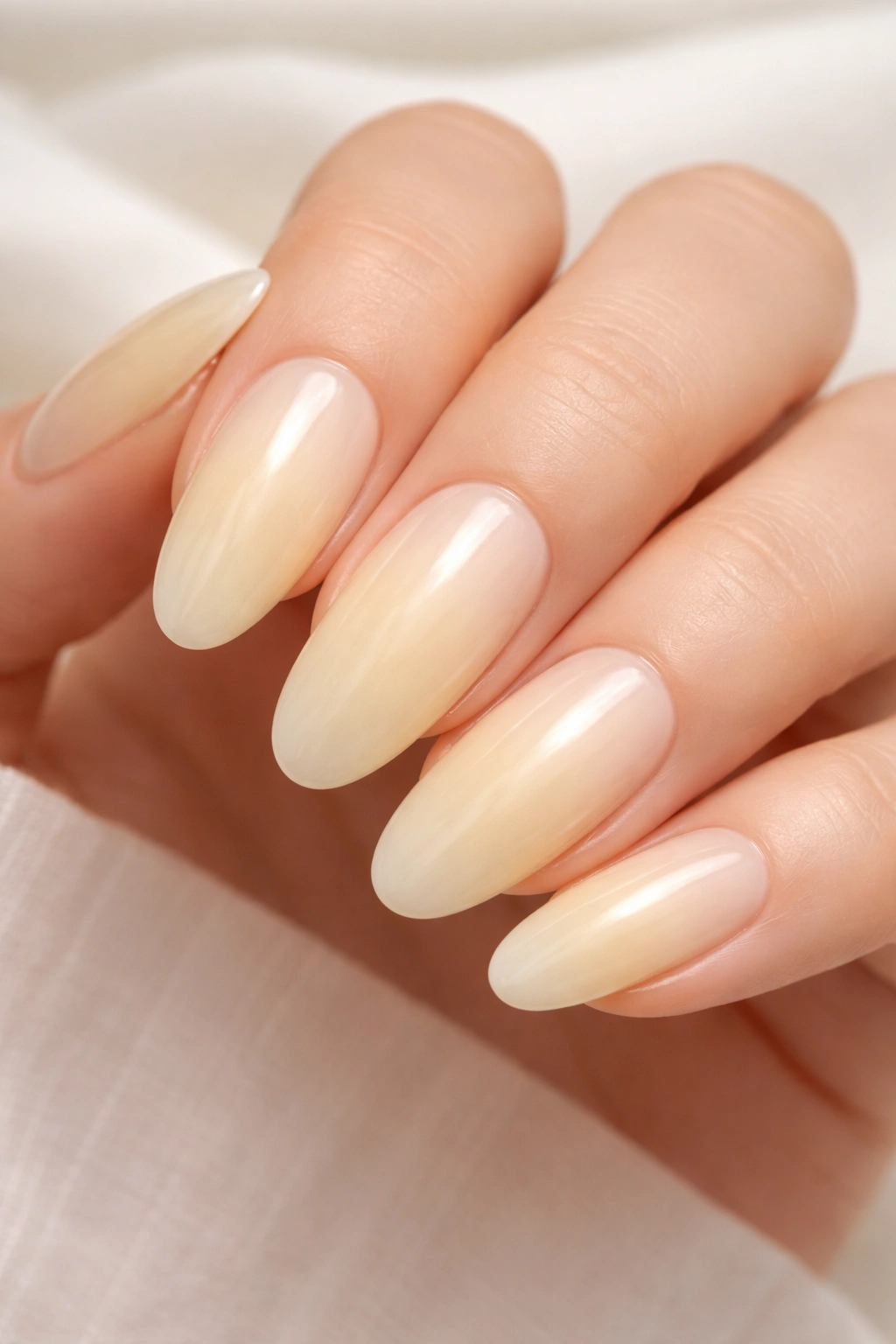 Close-up of soft yellow milk bath nails on long ovals
