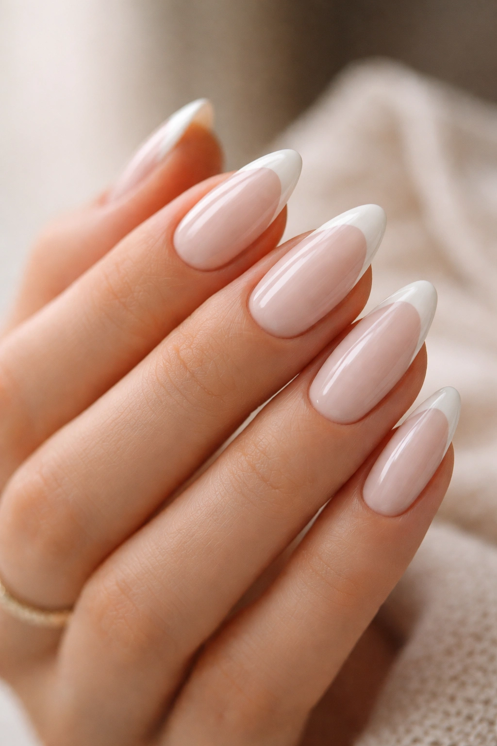 Almond nails with milky base and slim white French tips