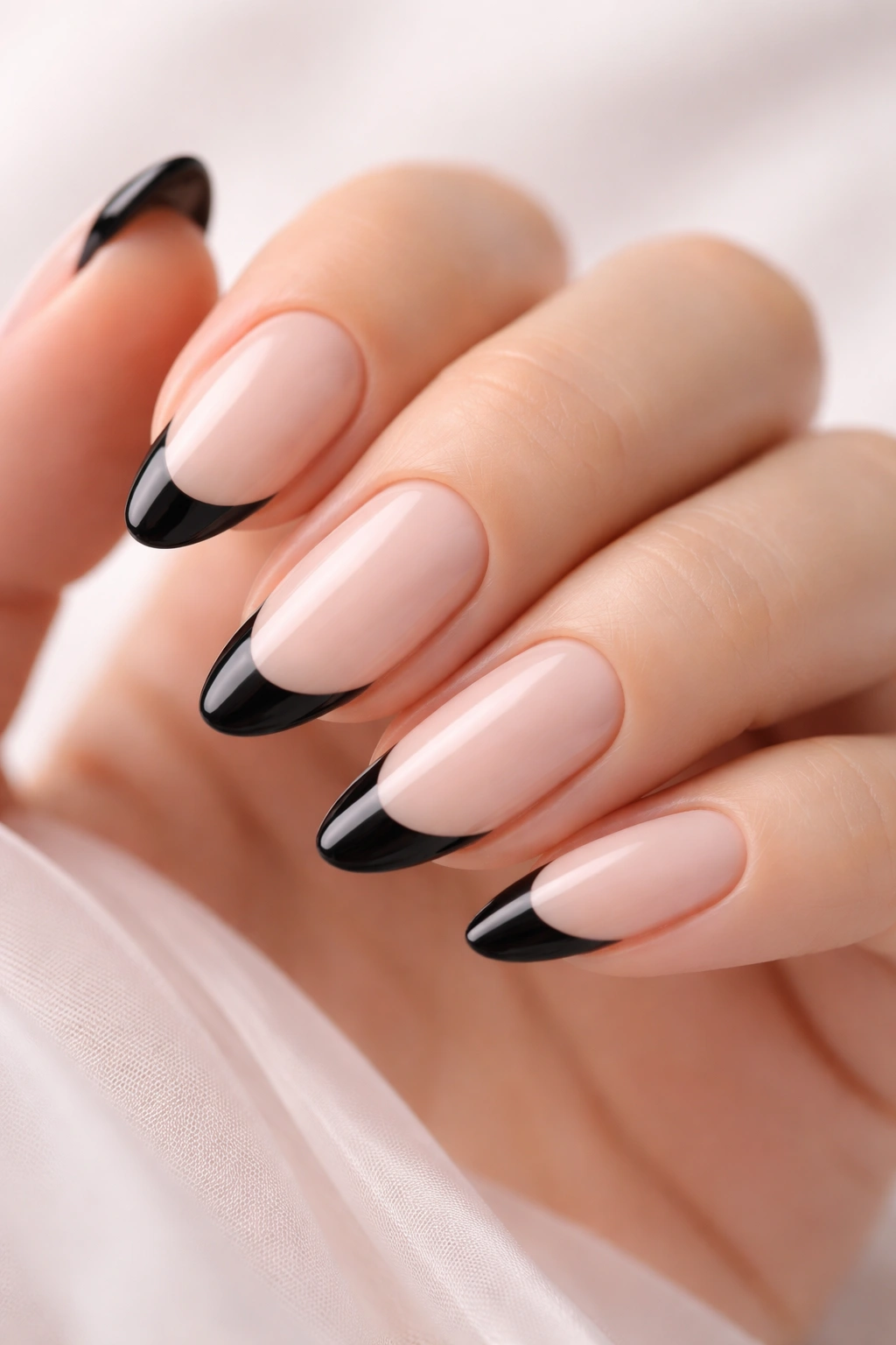 Close-up of nails with black tips on a milky nude base