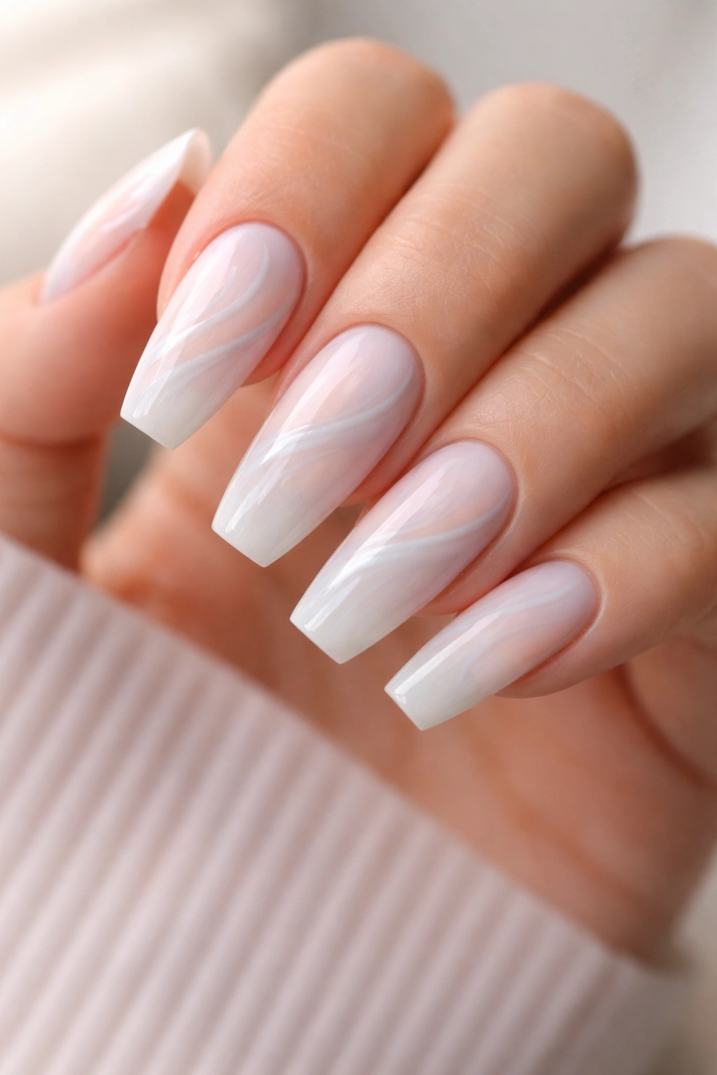 Close-up of ballerina nails with a cloudy milky white base and delicate pastel swirl ribbons.