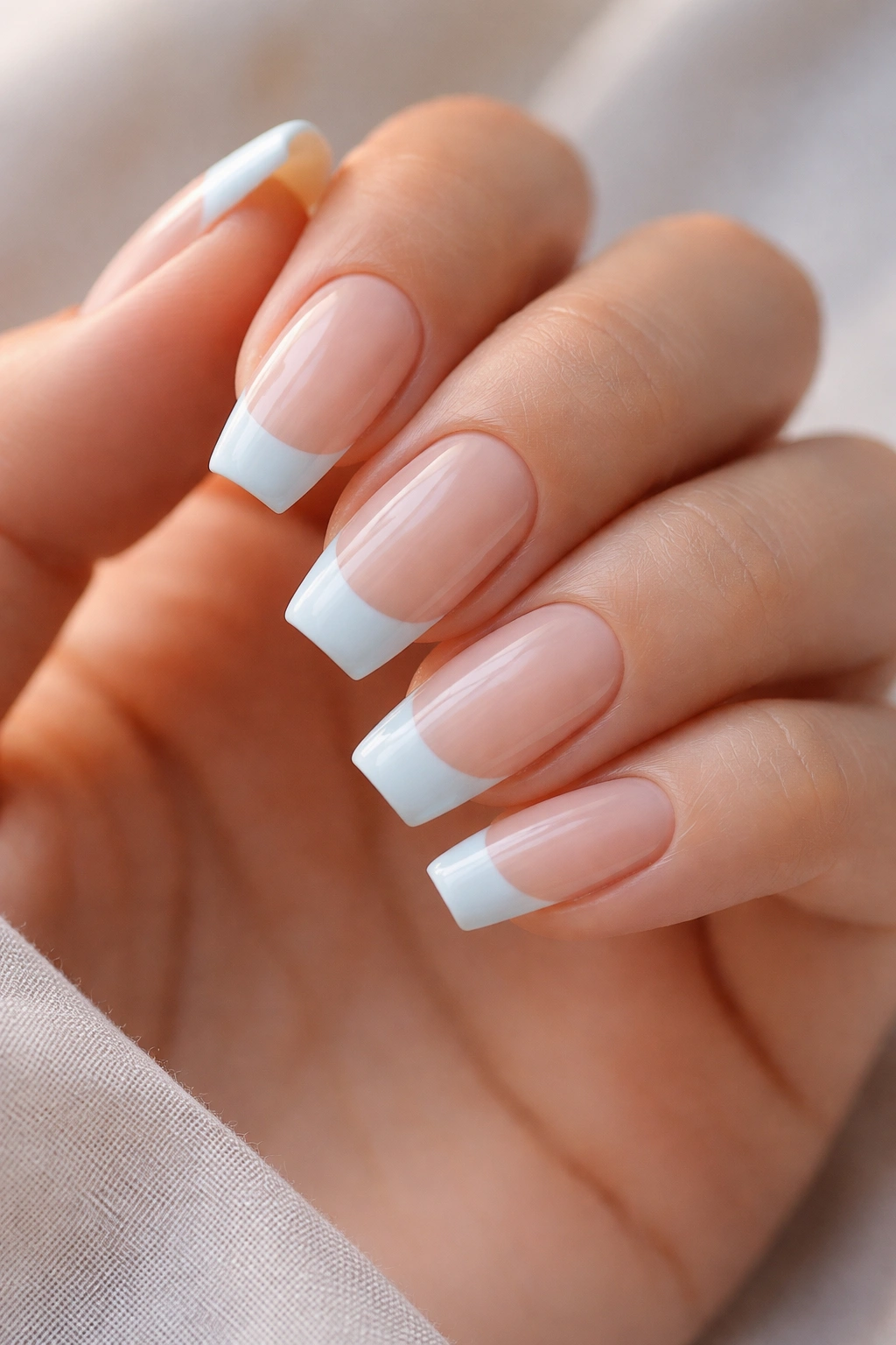 Milky blue French tips on nude base ballerina nails