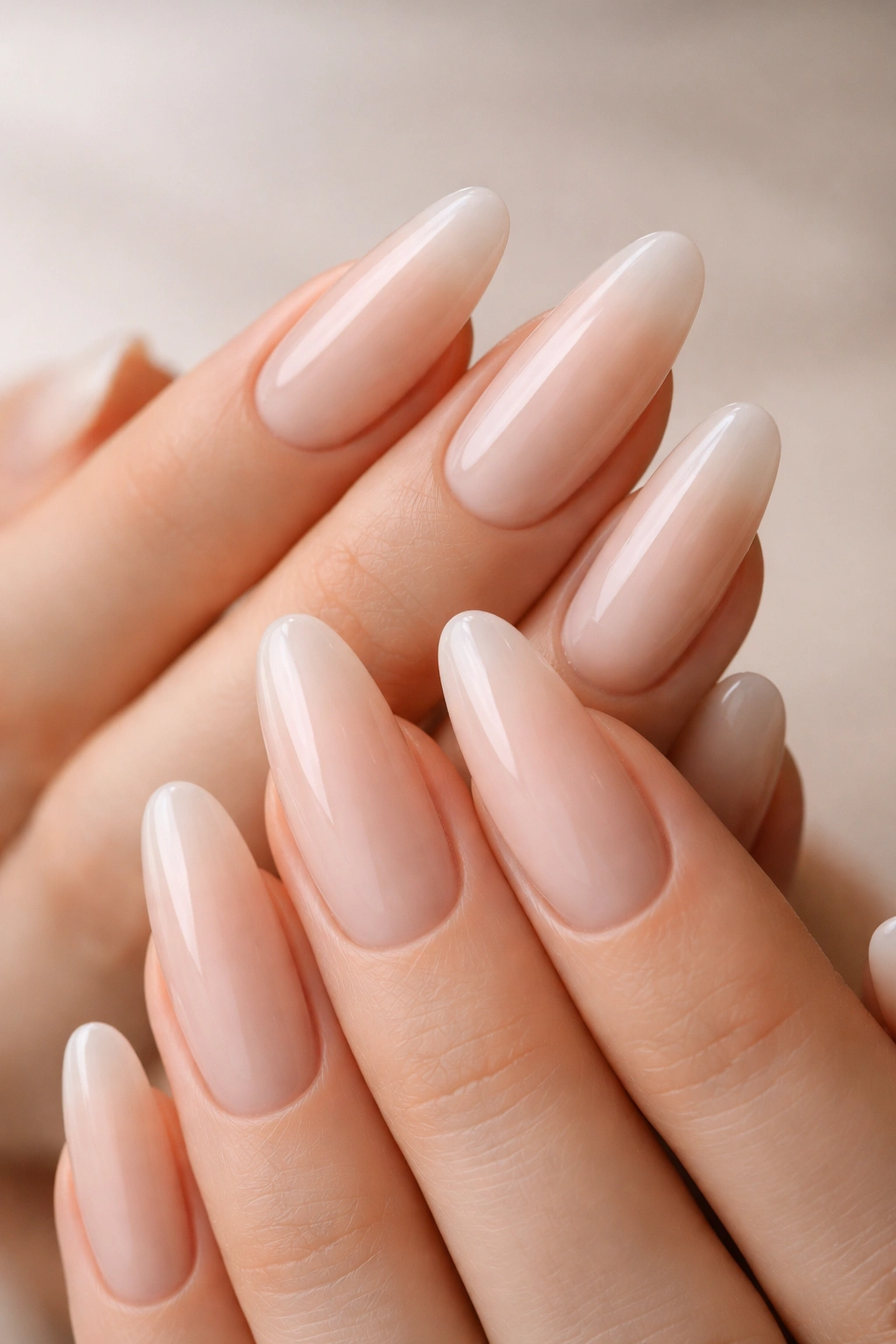 Close-up of milky nude long oval acrylic nails on hands