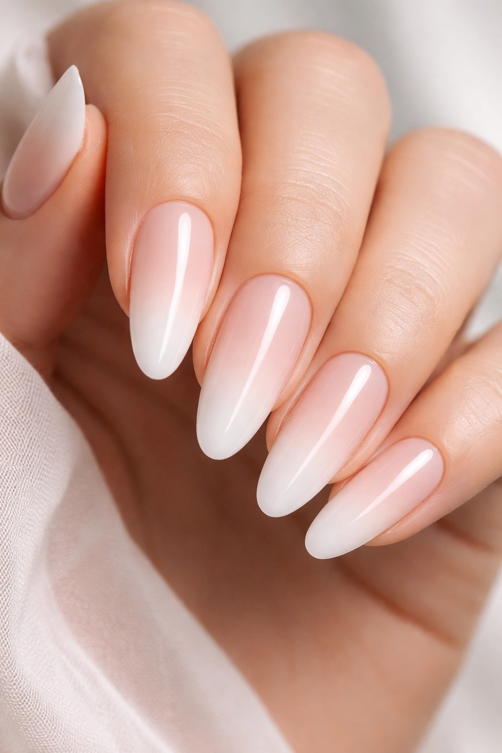 Milky ombré nails with subtle gradient and gloss close-up