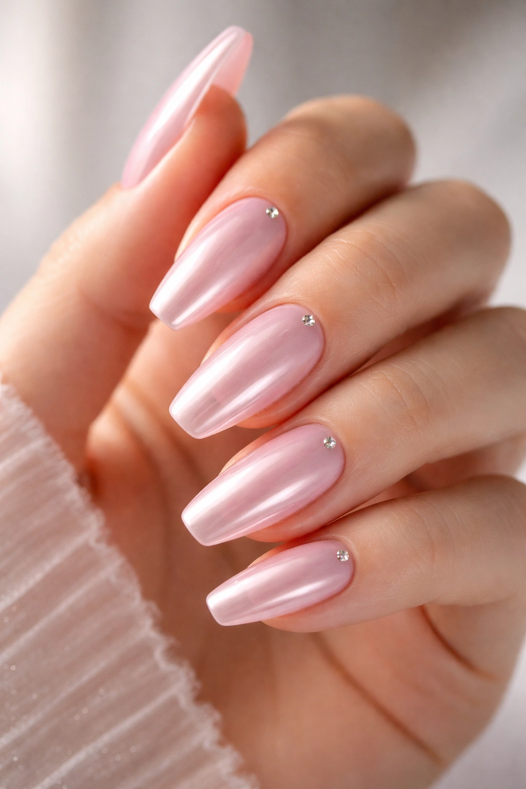 Milky pink chrome ballerina nails with crystal accents on ring fingers